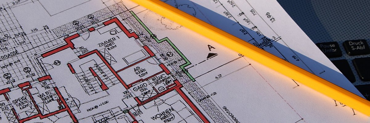 Der Plan von einem Gebäude liegt auf dem Tisch mit einem Stift zusammen Der Plan von einem Gebäude liegt auf dem Tisch mit einem Stift zusammen