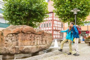 Brunnenstein mit Wanderern